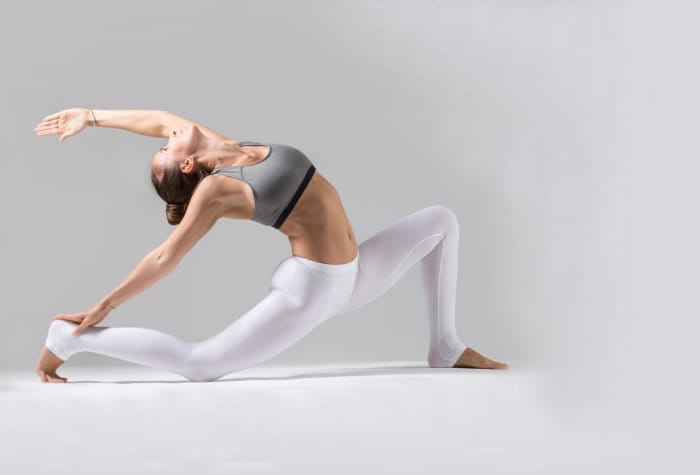 Young woman in Horse rider pose, grey studio background